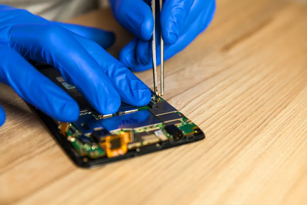 Technician replacing a cracked iPhone screen on-the-spot in Trinidad